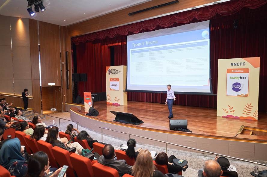 Krish Phua presenting on stage at the National Counselling & Psychotherapy Conference Singapore