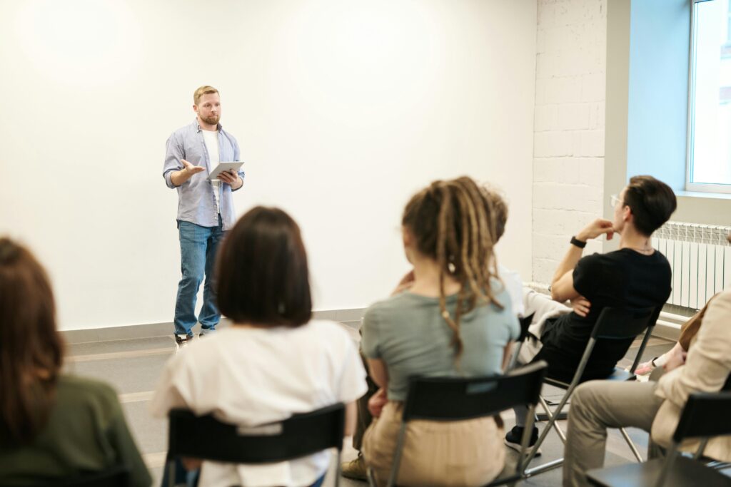 Man standing and holding a presentation in front of students