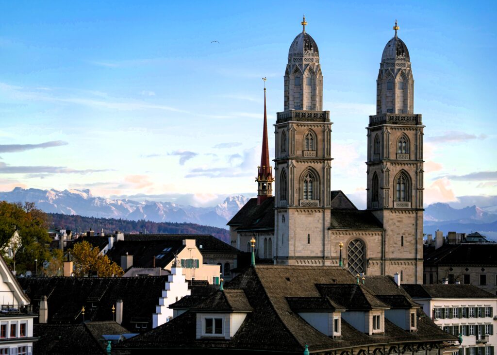The grossmuenster church in zurich with mountains in the background