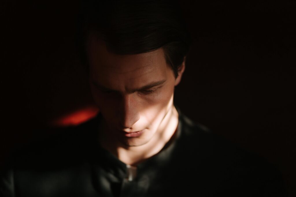 man in the dark looking down symbolising feeling down